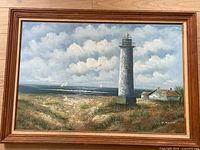Front view of framed lighthouse painting showing full artwork and frame