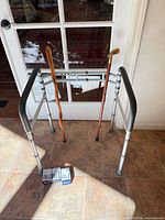 Overall lot showing toilet safety rail, two canes, three boxes of tips