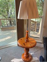 Full view of lamp showing wood table, chrome pole, fabric shade