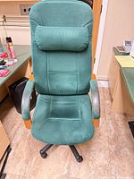 Front view showing upholstery, pillow, wooden arms, caster base