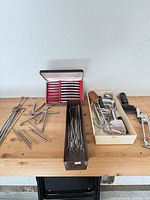 overview of entire lot on bench showing trays of utensils, skewers and gadgets