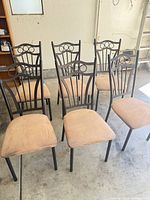 Six metal dining chairs grouped in garage
