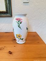 Front view of Tiffany & Co. white porcelain floral vase on wood surface