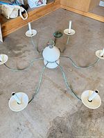 Chandelier overall view showing six arms, ceramic center, verdigris finish