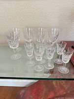All fourteen Waterford crystal cordial glasses grouped on shelf