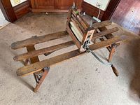 Full view of wooden folding bench with mounted clothes wringer