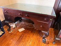 overall view of desk showing drawers, glass top, claw feet