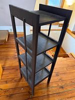 full front angled view of four-tier dark wood shelf