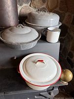 Overall view of all four enamelware items on stove