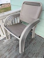 Stack of metal sling patio chairs on deck