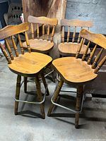 Four matching wood swivel bar stools grouped
