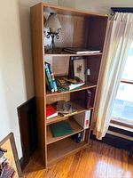 Full view of wood bookshelf with contents