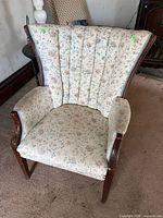 Front view showing floral upholstery, channeled back, wooden arms and legs