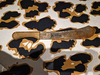 Full view of Incolma machete on table showcasing blade and handle