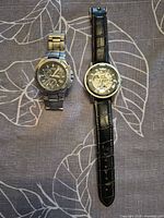 Both watches laid out side by side showing full view