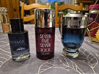 Three men’s cologne bottles lined up: Dior Sauvage, Seven Five Seven XXX, Paco Rabanne Invictus
