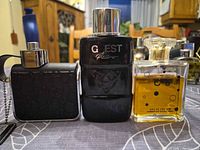 Three perfume bottles side by side on table