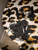 Three microphones with coiled cables and one long XLR cable on table