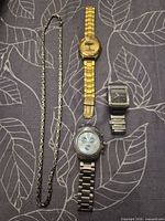 Full lot showing three wristwatches and chain necklace
