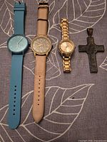 Front view of three watches and pendant