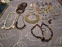 Group shot showing necklaces, bangles, bracelets, rings and earrings on fabric background