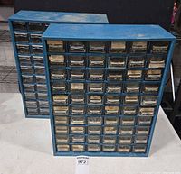 Front view of both blue hardware organizer cabinets with drawers closed