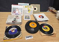 Overall view of two stacks of 45s, loose singles and sealed 8-track