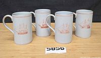 Front view of four Spode Trade Winds mugs showing ship motif and cylindrical shape