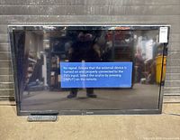 Front view of Panasonic flat screen TV with remote and power cord visible