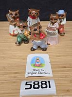 Group shot of six figurines and brochure