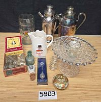 Group shot of all barware, glass stoppers, compote, pitchers, spoon, ceramic lid and coil