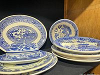 Group view showing oval platter, butter dish with lid, rectangular plate and stack of round plates