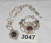 Necklace and bracelet laid out showing design, pendant and stones