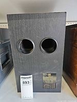 Subwoofer front showing two ports and cabinet finish