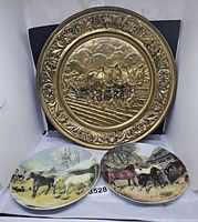 Brass charger and two horse plates front view