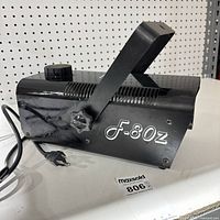 Left side view showing model marking F-80Z, power cord, handle and reservoir cap