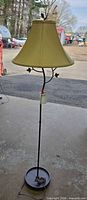 Full view of floor lamp showing base, stem, shade, leaf decorations