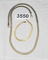 Necklace and bracelet laid flat displaying chain style and clasps