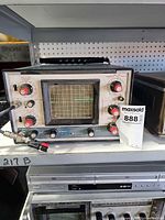 Front view of Heathkit IO-4550 oscilloscope showing screen, controls, probe leads and power status