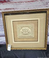 Front view of square framed art showing entire frame and relief