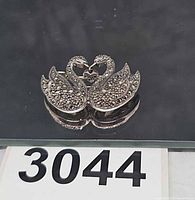 Front view of sterling double swan pin showing marcasite detail