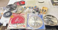 Overview of all saw blades, router bits, abrasive wheels and storage boxes on table