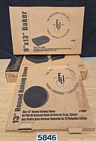 Three boxed Pampered Chef Family Heritage stoneware pieces showing product names and model numbers