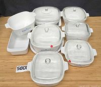 Full set of casseroles, lids, round dish and loaf pan arranged on table
