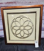 Front view of framed shadow box showing metal circle design and overall frame
