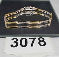 Side view of bracelet showing two-tone bar links and clasp