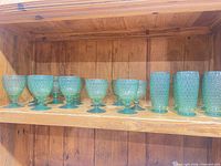 Single shelf view showing multiple green Boston pattern goblets and tumblers