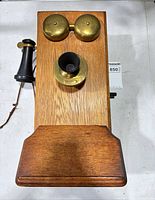 Front view showing oak body, brass bells, brass mouthpiece, black handset