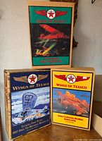 Three boxed Wings of Texaco coin bank airplanes