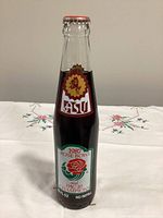 Front view of sealed 10-fl-oz Coca-Cola commemorative bottle with ASU rose bowl graphics